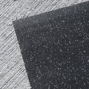 Close-up of a black recycled rubber fitness mat for weightlifting area against a light gray background