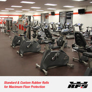 Gym interior with stationary bikes and exercise equipment on top of rubber roll  gym flooring.