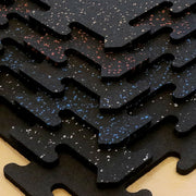 Close-up of interlocking rubber gym tiles showing the different color options.