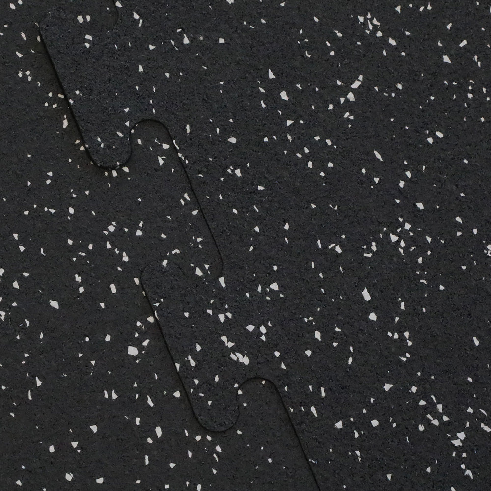 Close up of the interlocking on a gray fleck rubber gym tile.