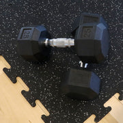 Pair of black hexagonal dumbbells on a gray fleck rubber gym tile.