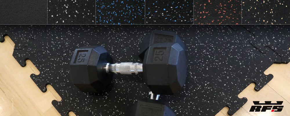 Hex dumb bells sitting on a 24 x 24 interlocking black rubber tile with gray specks