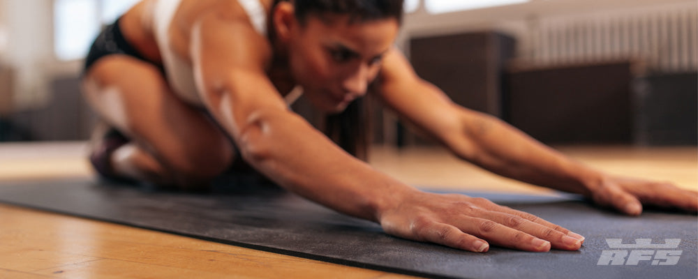 Person stretching on a yoga mat in a home setting