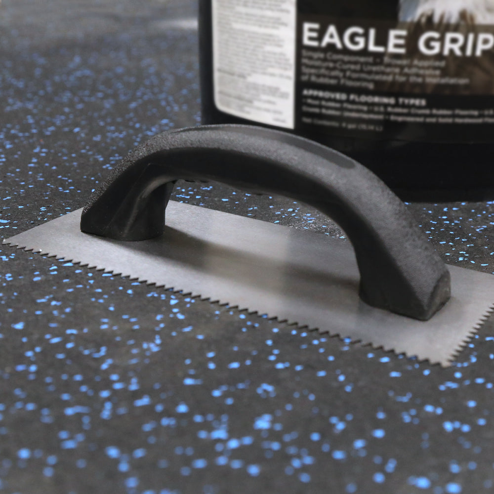 V-Notch Trowel sitting on a rubber floor.