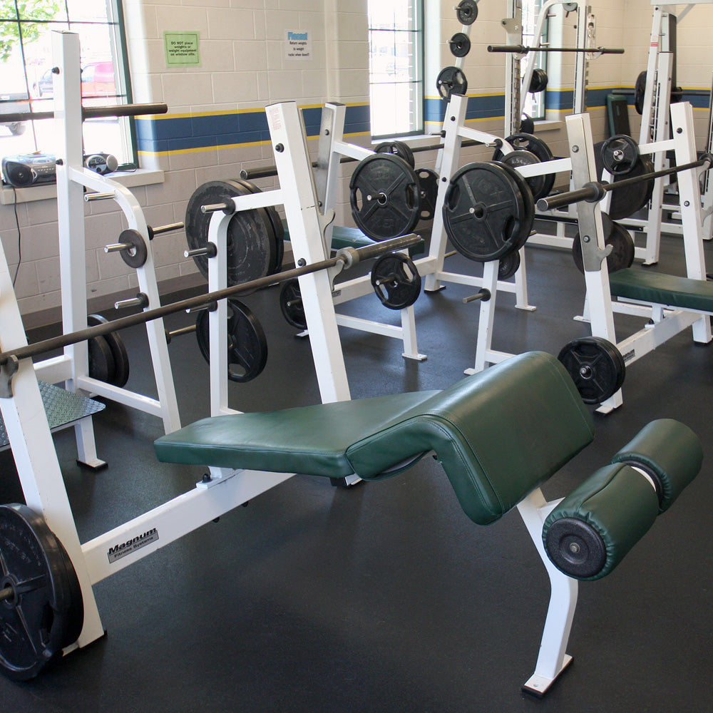 Gym equipment including weight benches and barbells in a fitness center with 8mm Rubber Rolls flooring.