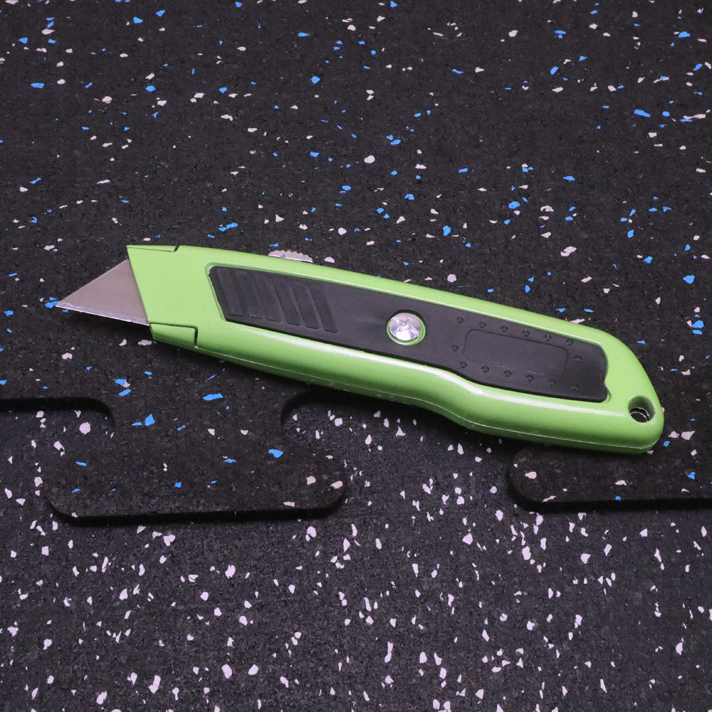 Green utility knife on a black speckled surface
